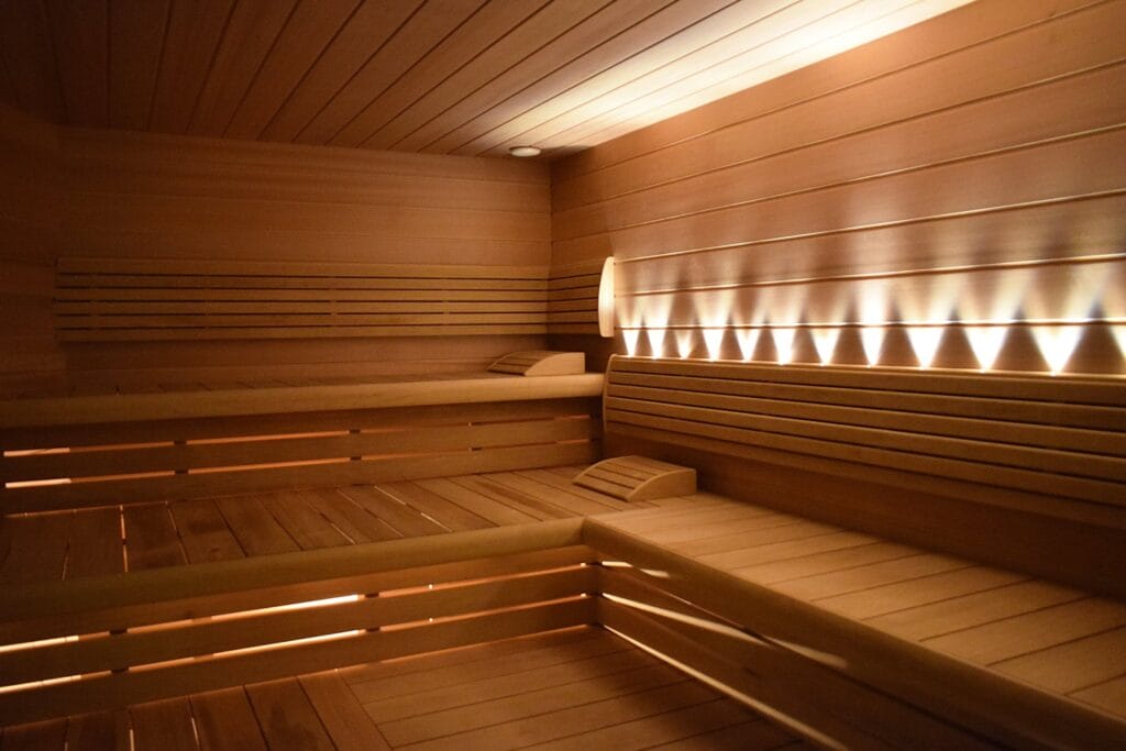 Wellness triple centrum v Košiciach so saunou s drevenými lavicami a osvetlením pre dokonalý relax a fitness.