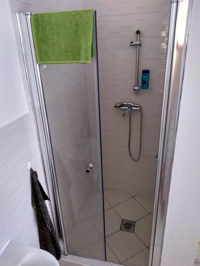 Kúpeľňa s preskleným sprchovacím kútom a toaletou v masážnom salóne.