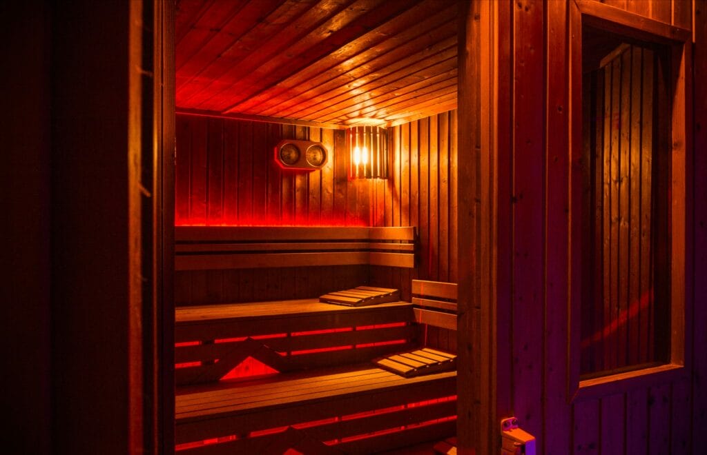 Drevená sauna v Relaxačnom centre Kryštál Prešov s červenými svetlami.