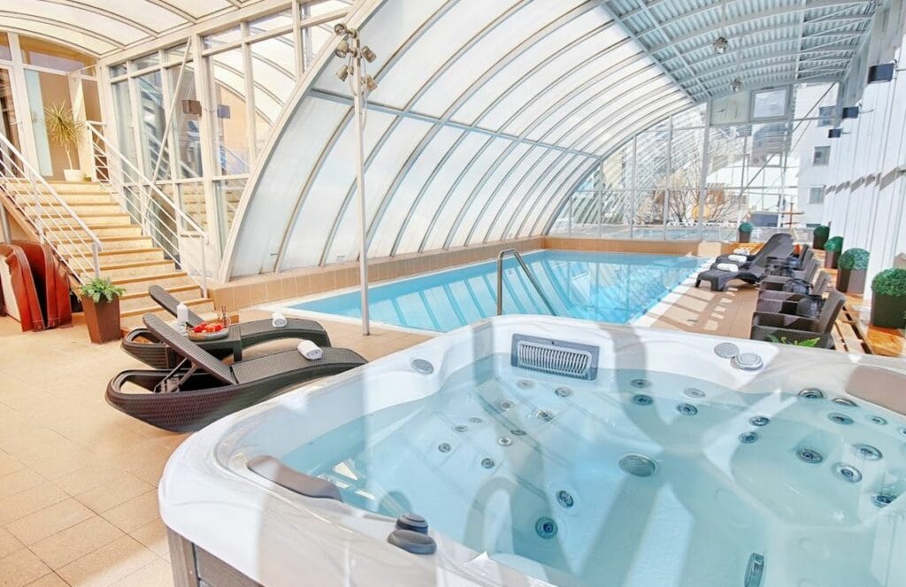 Vnútorný bazén s jacuzzi a ležadlami sa nachádza vo wellness centre Hotela Magnólia Piešťany.