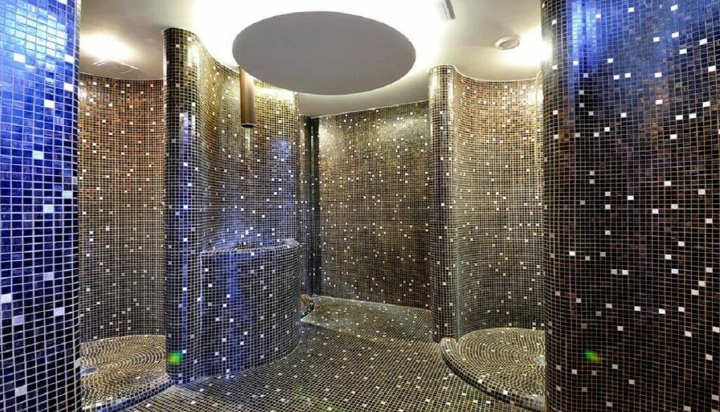 Luxusná kúpeľňa s množstvom zrkadiel a sklenených obkladov určená pre wellness a spa zážitky v Hoteli International Veľká Lomnica.