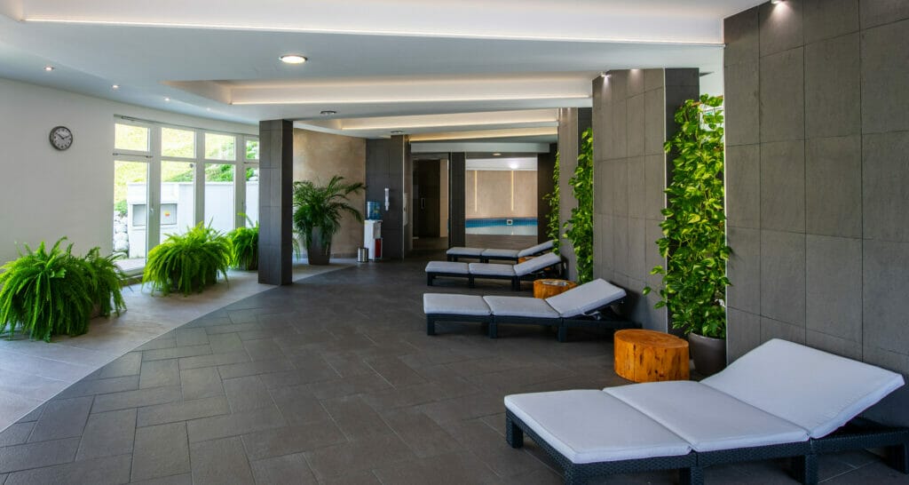 Wellness centrum v Šport hoteli Donovaly s chodbou s útulnými ležadlami a sviežimi rastlinami.