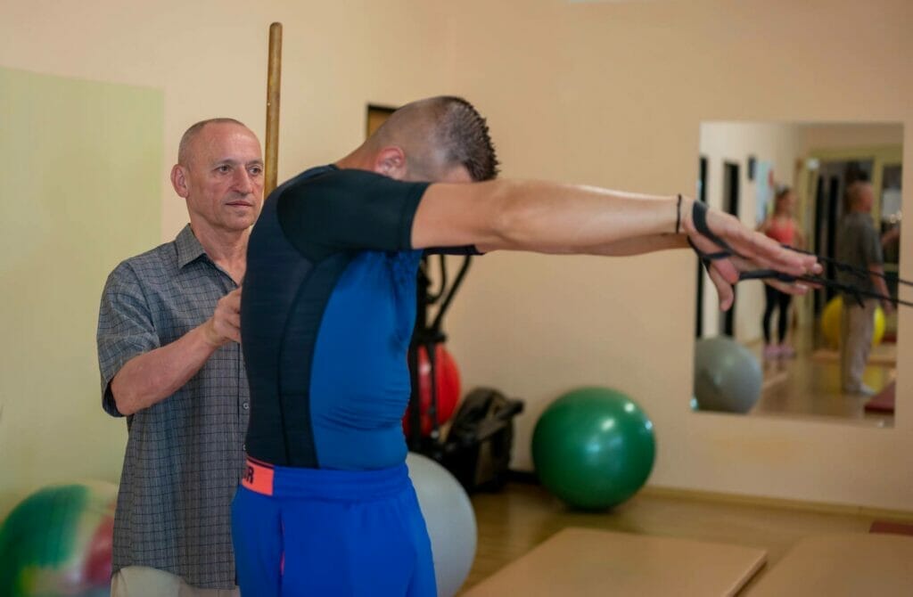 Muž drží tyč v telocvični na tréning tela.