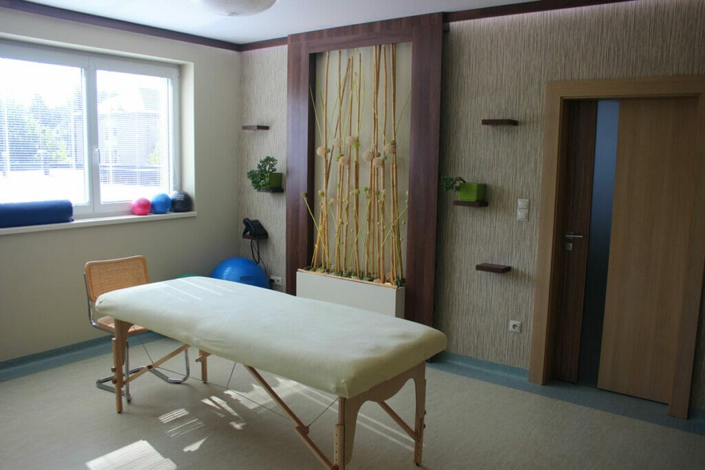 Personalizovaná miestnosť fyzioterapeuta s masážnym stolom.