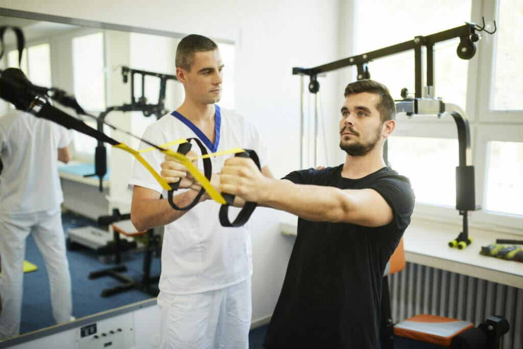 Muž a žena cvičia trx cvičenie v telocvični Fyziatricko-rehabilitačného oddelenia Procare Vranov nad Topľou.