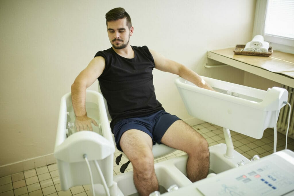Muž sedí na stroji v kúpeľni vo Fyziatricko-rehabilitačnom oddelení Procare Vranov nad Topľou.