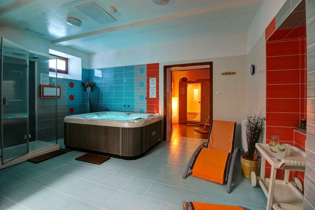Wellness centrum v hoteli Avalanche Štôla s jacuzzi vaňou a sprchou.