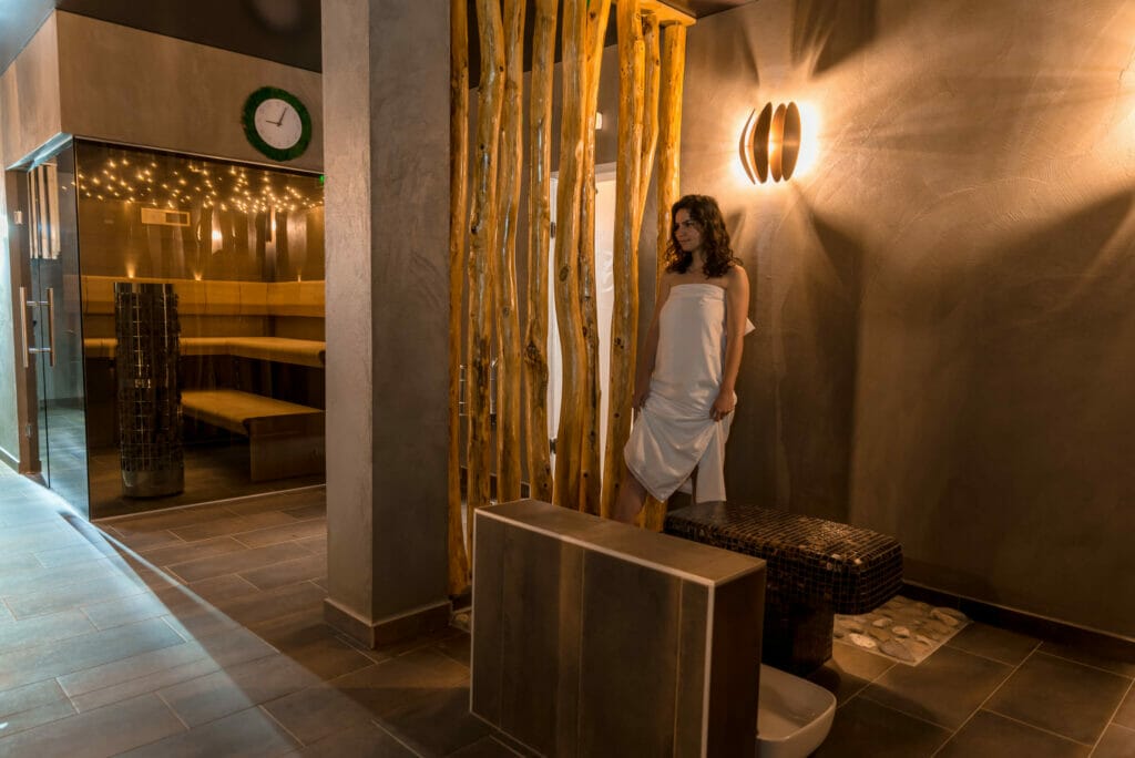 Žena stojí v saunovej miestnosti hotela Dastan Levice a propaguje wellness.