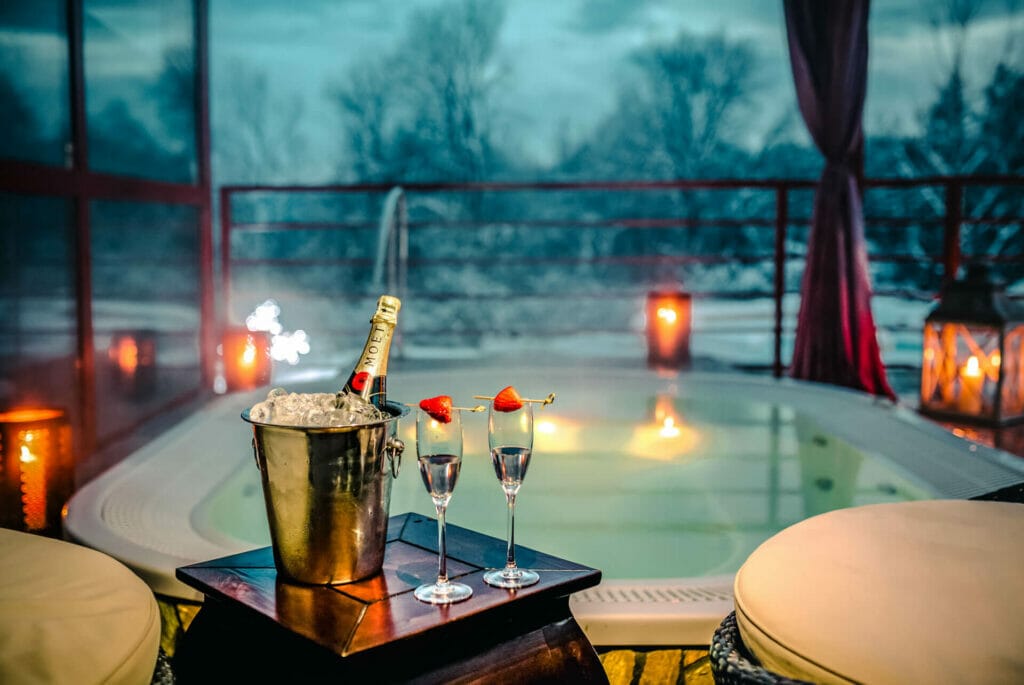 Wellness zážitok z vírivky na luxusnom balkóne so šampanským a jahodami.