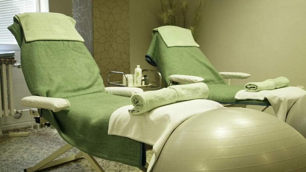 Wellness v hoteli SOREA Máj Piešťany s masážnymi kreslami a zelenými uterákmi.
