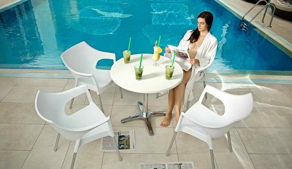 Žena sediaca za stolom pri bazéne vo wellness centre v hoteli Sitno Vyhne.