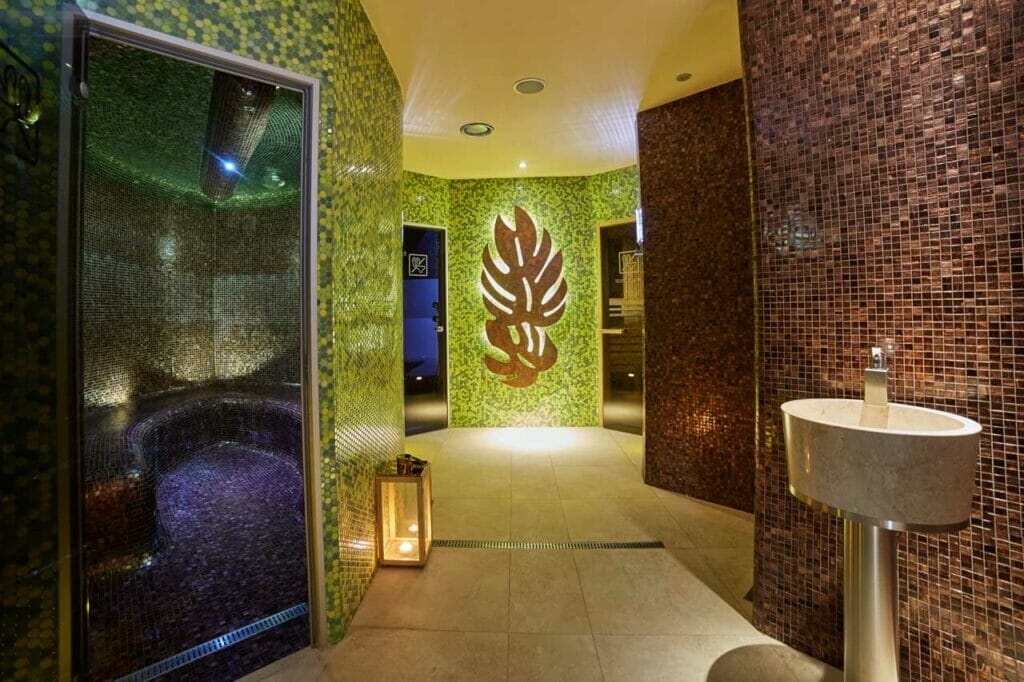 Hotelové wellness centrum Turiec Martin s kúpeľňou so zelenými obkladmi a umývadlom.