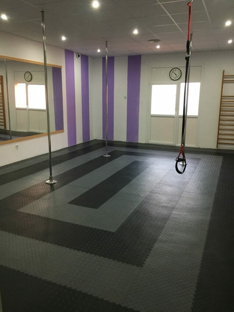 Wellness a fitness centrum v Topoľčanoch s čiernou podlahou a fialovými stenami.