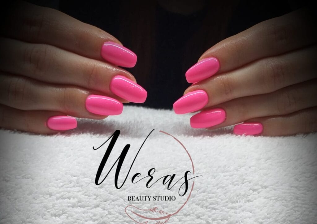 Ženské ružové nechty s nápisom woras v kozmetickom štúdiu