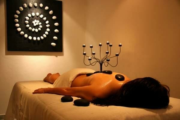 Žena, ktorá si užíva wellness v Hoteli Hubert Gerlachov pri masáži lávovými kameňmi.