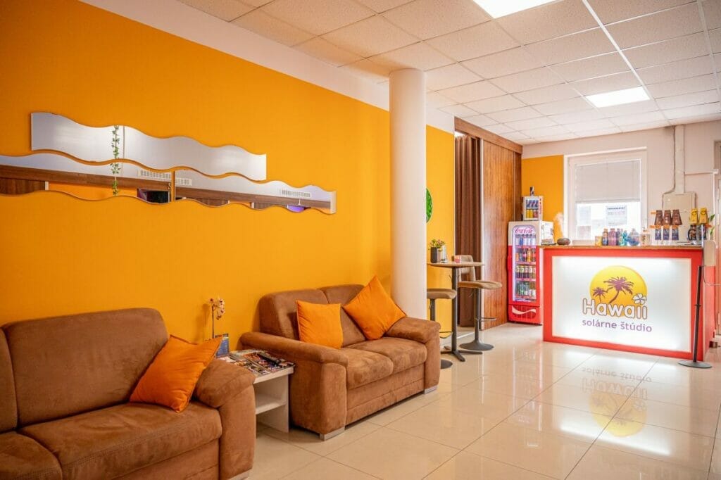 Recepcia so žiarivými oranžovými stenami a moderným nábytkom.